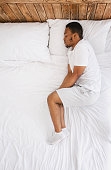 african-american-guy-sleeping-lying-in-bed-at-home-top-view.jpg