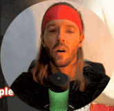 a man singing into a microphone with a red headband on