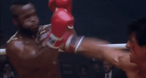 two men are boxing in a ring with red gloves on .