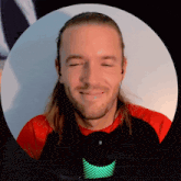 a man with long hair is smiling in front of a microphone