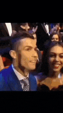 a man in a suit and tie is smiling next to a woman .