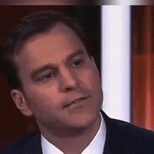a man in a suit and tie is making a serious face .