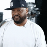 a man with a beard is wearing a ny hat