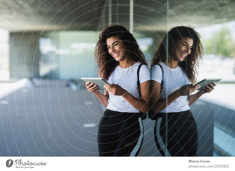 2525402-mixed-girl-smiling-while-using-her-tablet-in-the-city-photocase-stock-photo-large.jpeg