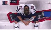 a football player with the number 12 on his jersey kneeling down