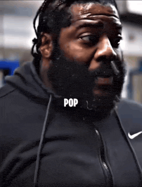 a man with a beard is wearing a black nike jacket