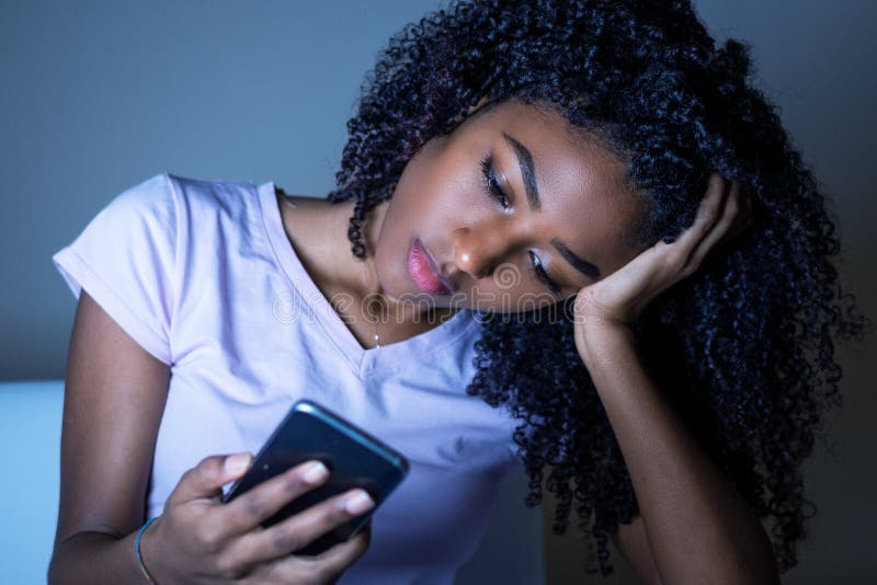 portrait-black-girl-holding-phone-night-woman-using-cellphone-148280899.jpg