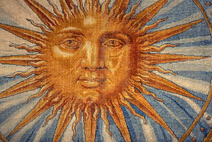 This may contain: the sun is depicted in this tapestry with blue and yellow colors, as well as an image of a man's face