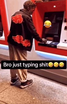 a man wearing a jacket with clouds on it is using an atm machine