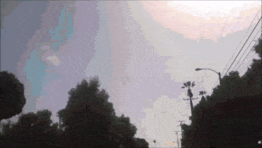 a blurry picture of a street with trees and telephone poles