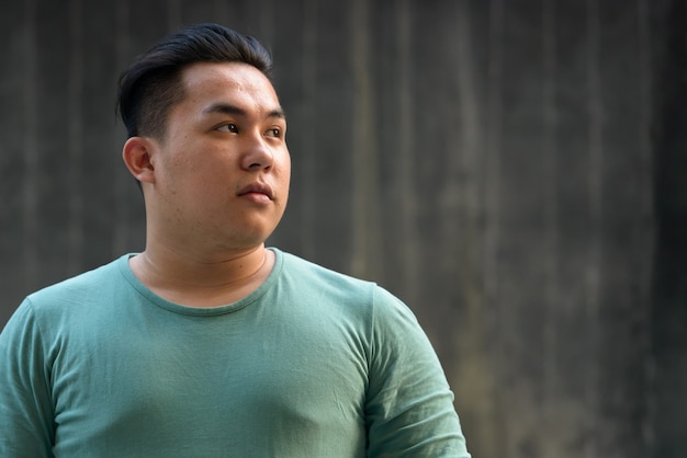 portrait-young-handsome-overweight-filipino-man-against-concrete-wall-outdoors_251136-64734.jpg