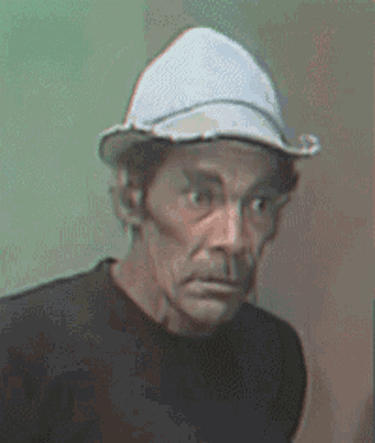 a man wearing a white hat and a black shirt is looking at the camera