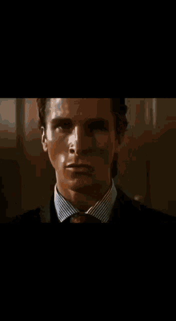 a close up of a man 's face in a dark room with a blurred background .