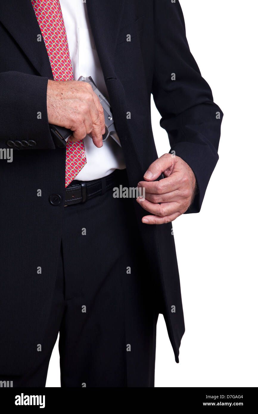 an-adult-wearing-a-suit-pulling-a-9mm-gun-out-of-its-holster-beneath-D7GAG4.jpg