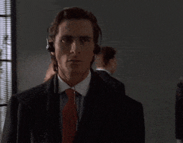 a man wearing headphones and a tie looks at the camera