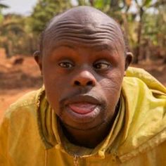 This may contain: a man in a yellow jacket is making a face with his tongue out and looking at the camera