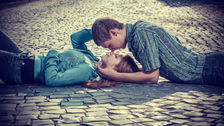 [Image: young-couple-laying-on-a-street-and-kissing.jpg]