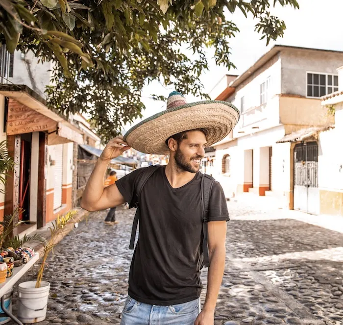 Smiling-caucasian-man-wearing-sombrero-in-streets-of-Cancun.jpg.webp
