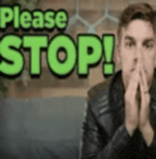 a man is sitting in front of a sign that says please stop !