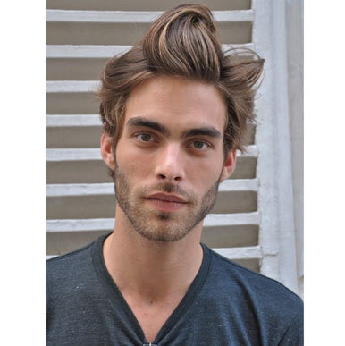 This may contain: a young man with a messy top knot looks at the camera while wearing a gray v - neck shirt