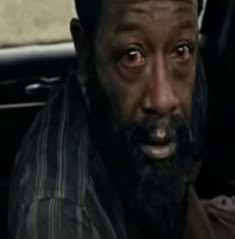 This may contain: a man with a black beard is sitting in a car
