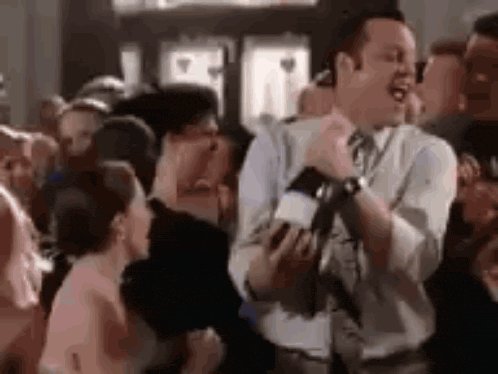a man is dancing in a crowd of people at a party .