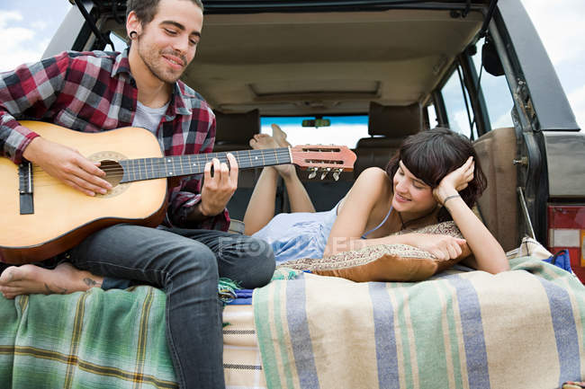 focused_165288342-stock-photo-young-man-playing-guitar-girlfriend.jpg