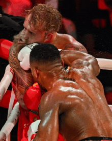 two boxers are fighting and one has a tattoo on his back