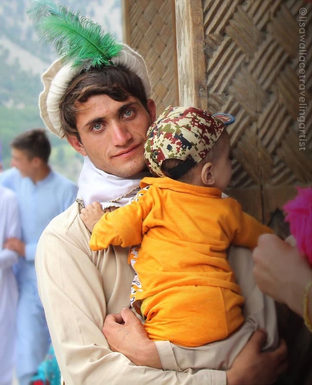r/pakistan - A Kalash man and baby at the summer festival of the Kalash people, in Rumboor Valley, Pakistan