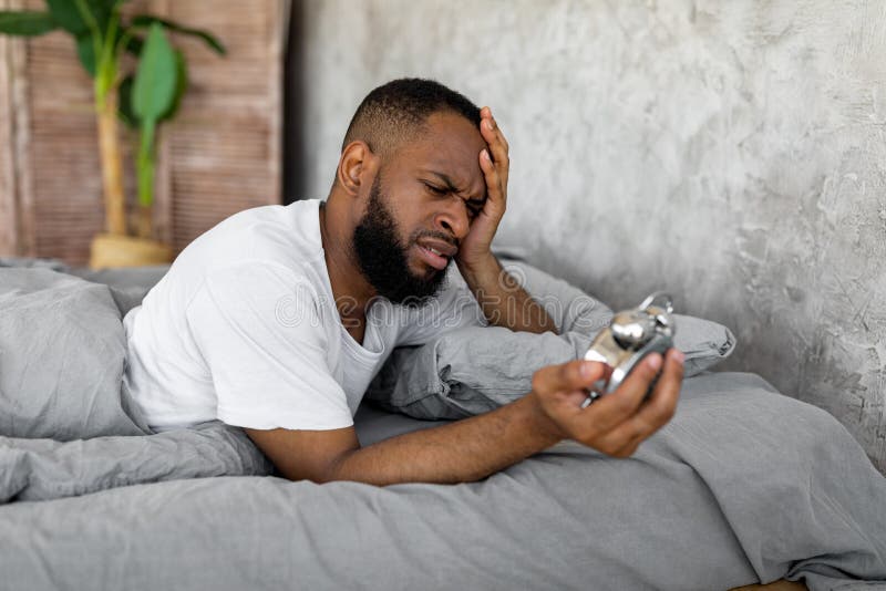 black-man-suffering-insomnia-looking-clock-bed-shocked-yound-black-man-looking-alarm-clock-lying-bed-home-230923951.jpg