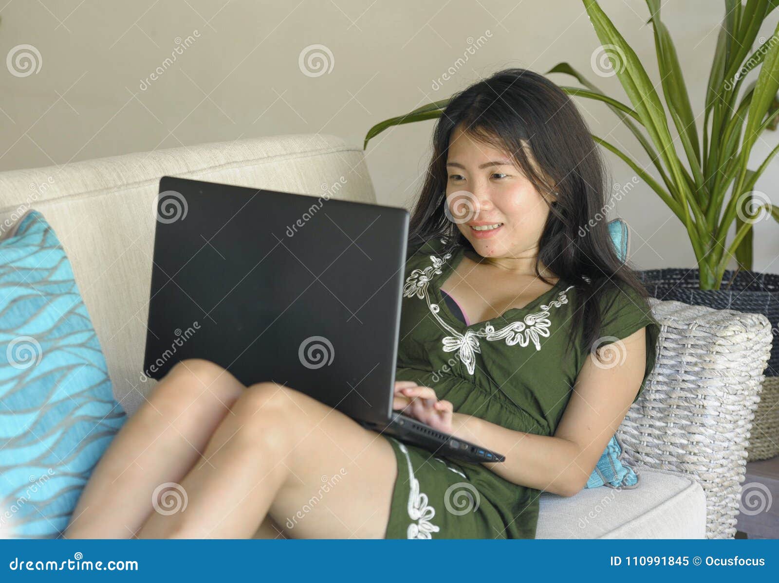 young-beautiful-relaxed-asian-chinese-woman-her-s-s-lying-happy-living-room-home-sofa-couch-working-using-computer-110991845.jpg