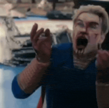 a man with blood on his face is making a funny face while wearing gloves .