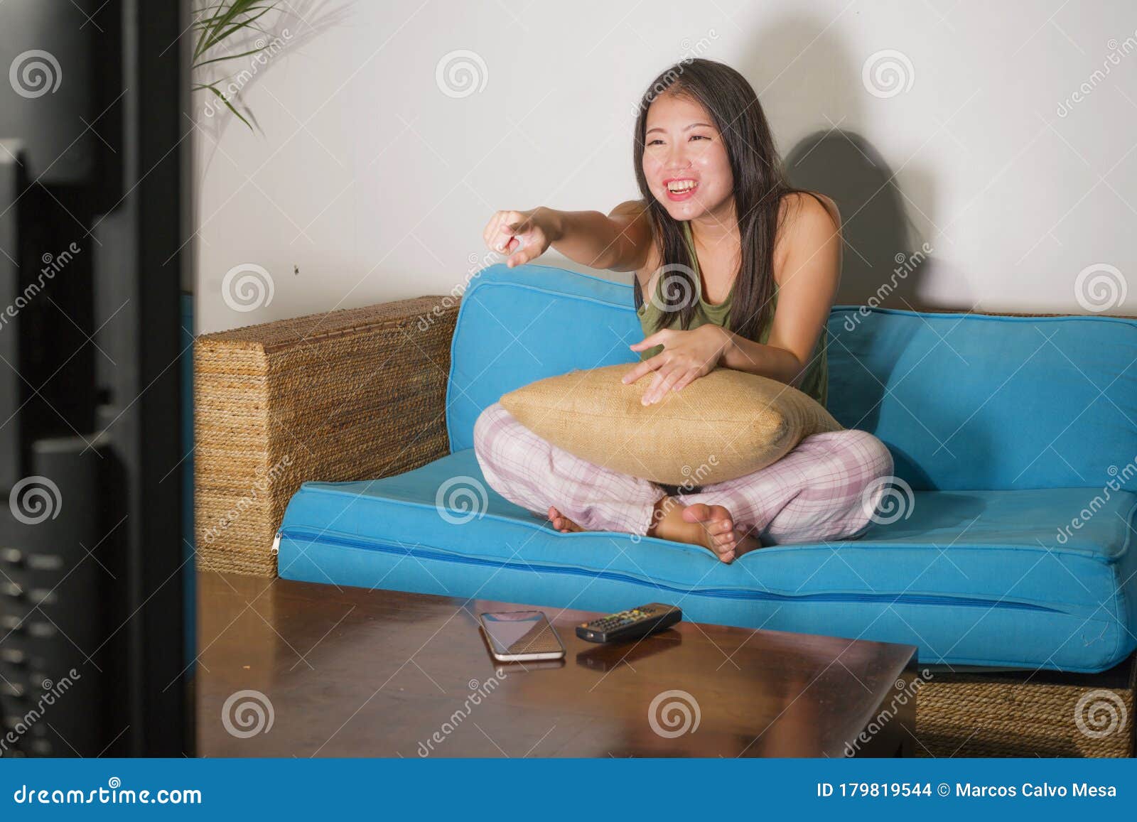 home-lifestyle-portrait-young-pretty-happy-asian-chinese-woman-laughing-watching-korean-comedy-tv-show-sitting-living-179819544.jpg
