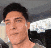 a close up of a man 's face while sitting in the back seat of a car