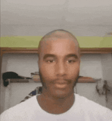 a man with a beard and a bald head is wearing a white shirt .