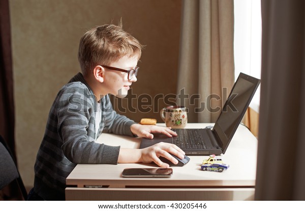 happy-boy-sitting-his-desk-600w-430205446.jpg