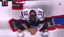 a football player with the number 12 on his jersey is kneeling down