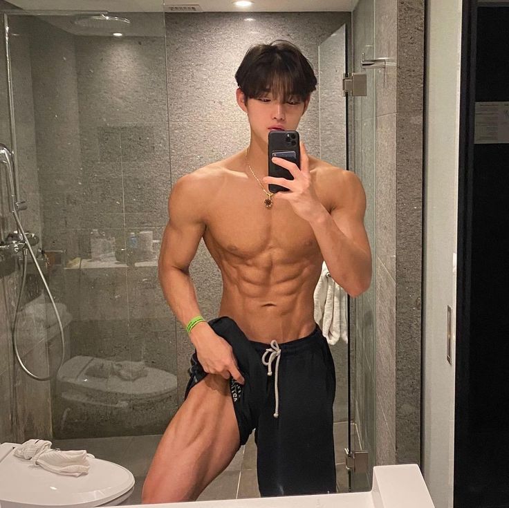 This may contain: a shirtless man taking a selfie in front of a bathroom mirror with his cell phone