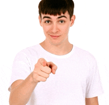 a young man in a white t-shirt points at the camera
