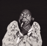 a person wearing headphones covering their mouth with their hand