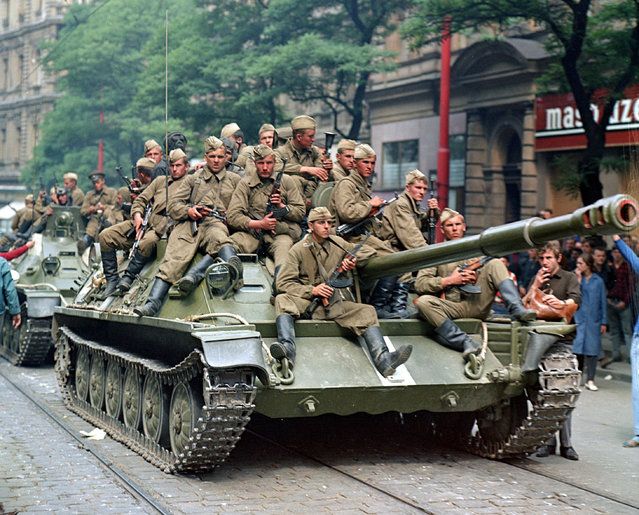 Soviet Army soldiers sit on their tanks in front of the ...