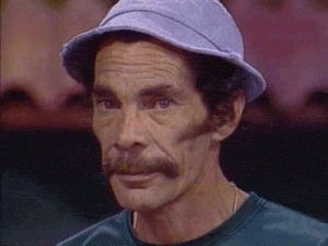 a man with a hat and a mustache is wearing a green shirt