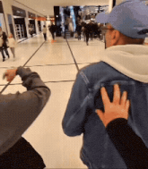 a man in a blue hat and a denim jacket is being held by a woman