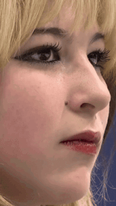 a close up of a woman 's face with a small spot on her nose