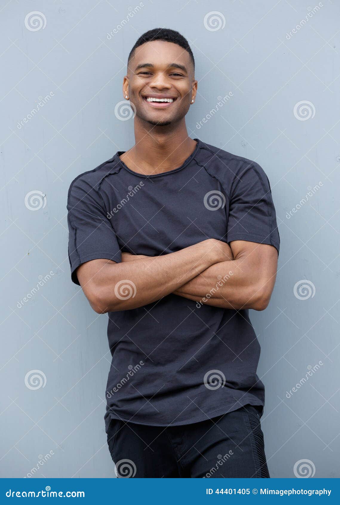 friendly-black-man-smiling-arms-crossed-portrait-against-gray-background-44401405.jpg