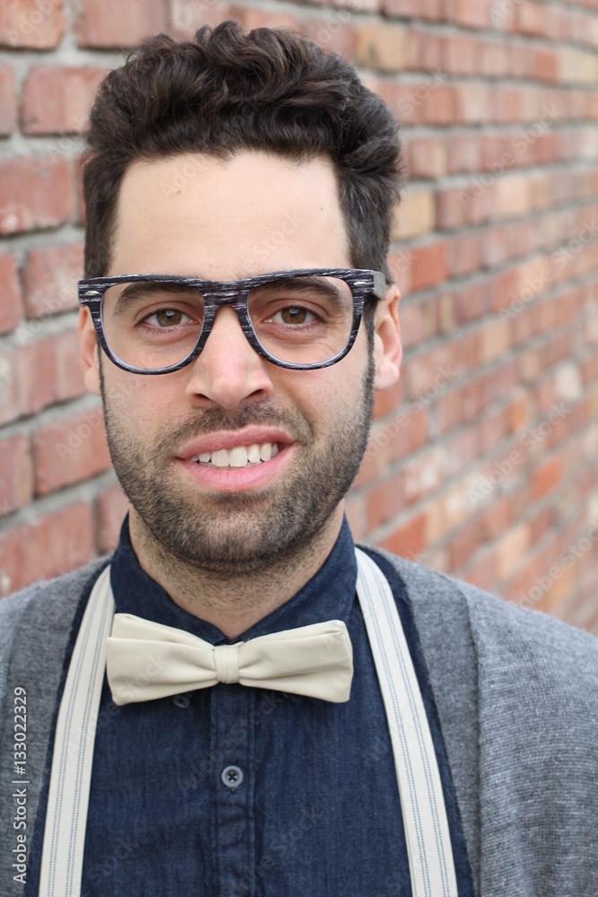 Nerd Guy With Glasses, Bow Tie, and Brick Wall Background Stock Photo |  Adobe Stock