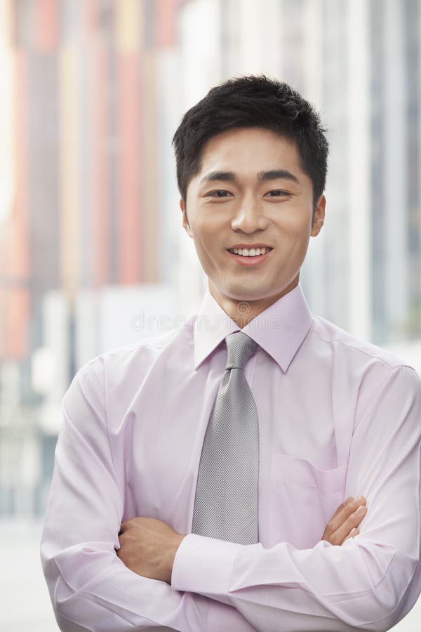 portrait-smiling-young-businessman-arms-crossed-outdoors-beijing-china-31106179.jpg