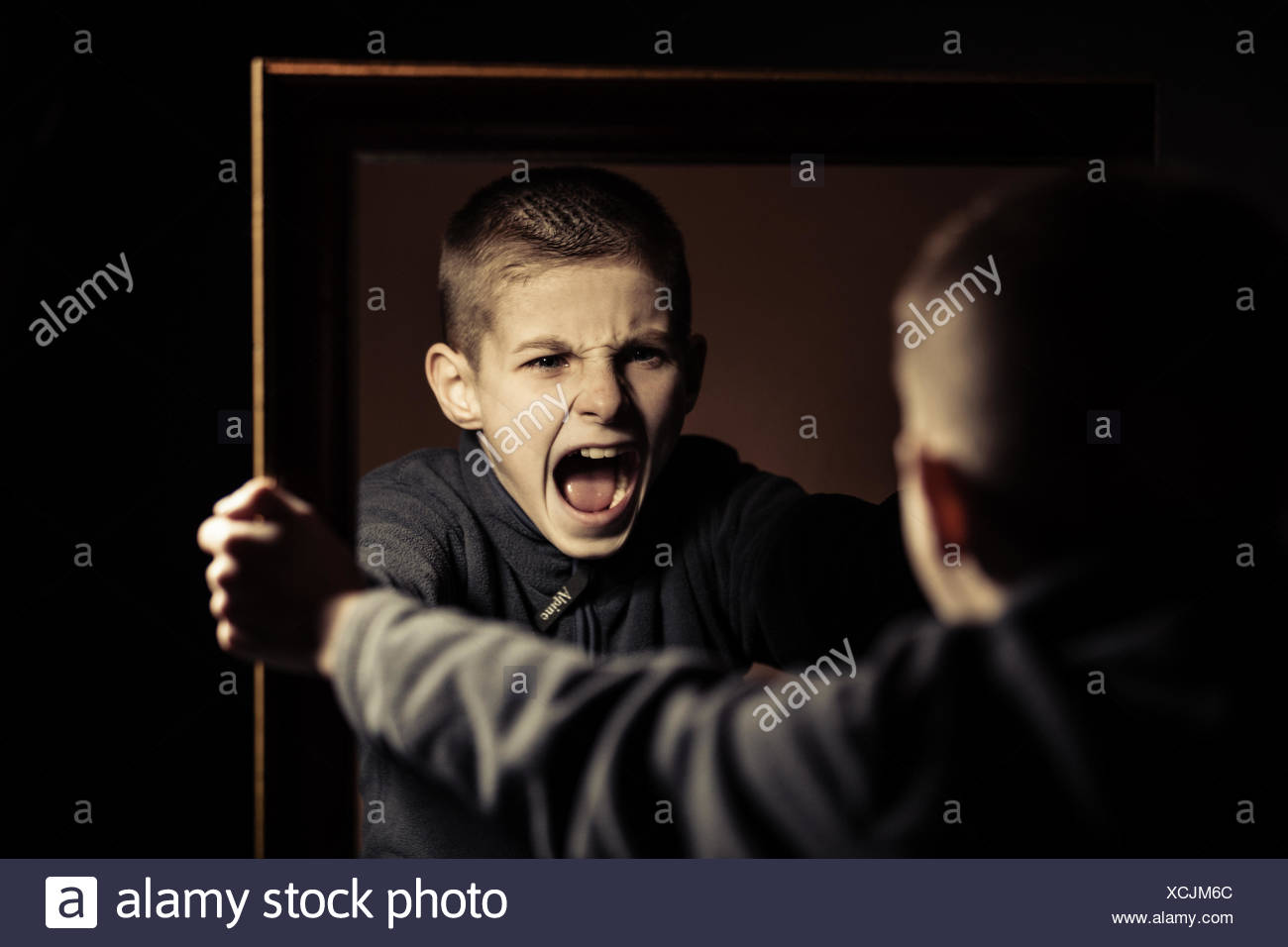 angry-boy-shouting-on-his-own-mirror-reflection-XCJM6C.jpg