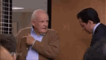 a man in a suit and tie is pointing at another man in a suit and tie .