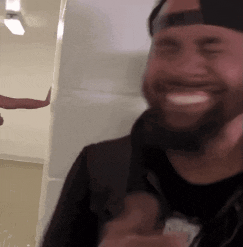 a man with a beard wearing a hat is smiling